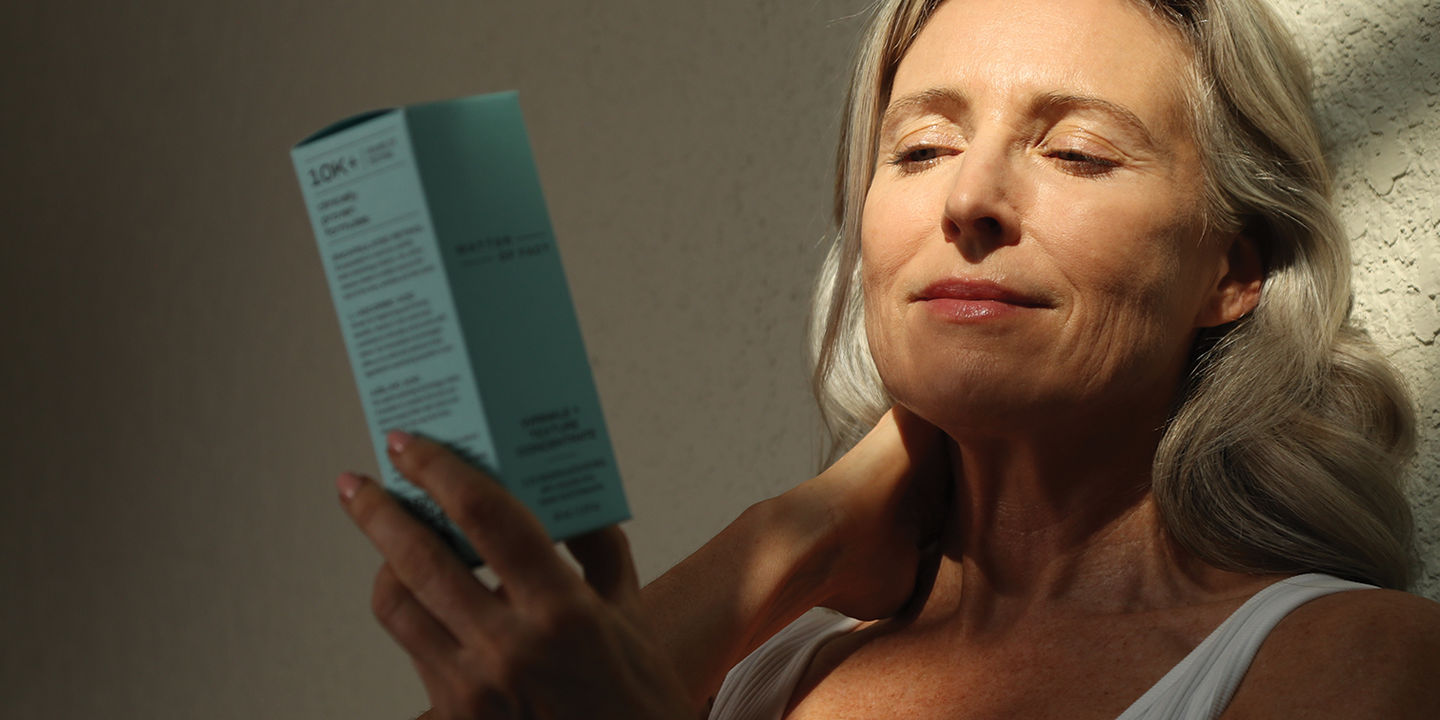 Image of a woman holding MATTER OF FACT skincare packaging.