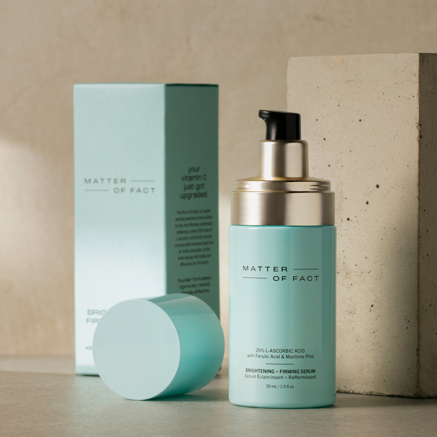 MATTER OF FACT SKINCARE BRIGHTENING AND FIRMING SERUM product vessel on a beige background with the product packaging and applicator visible